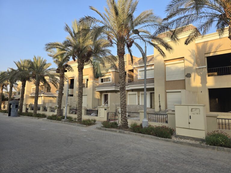 Palm-lined street in front of townhouses at Sarai, New Cairo