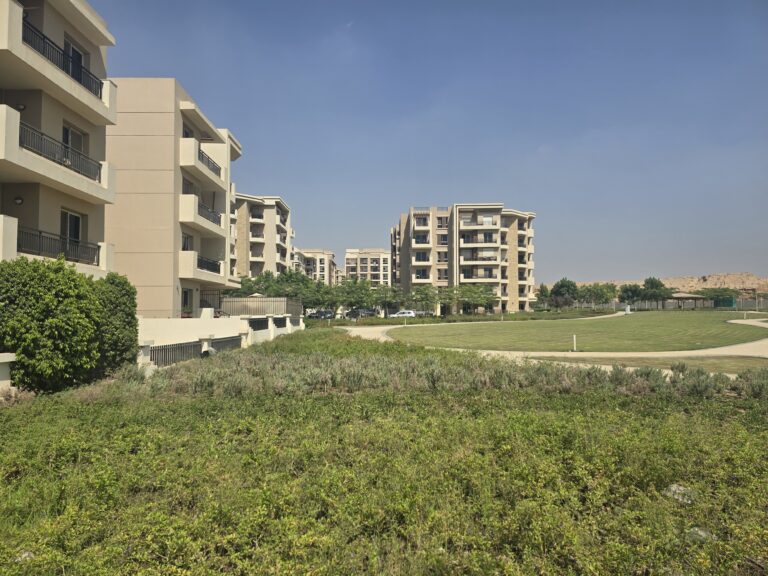عمارات سكنية تطل على مساحة خضراء واسعة في كمبوند تاج سيتي، القاهرة الجديدة